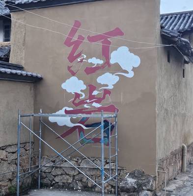 The Hongyan mural in progress, with clouds painted around bold red calligraphy